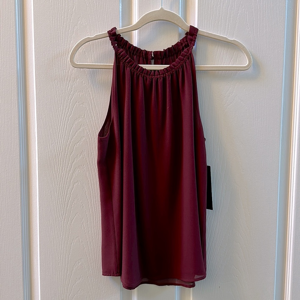 Burgundy flowy tank. Touched collar with covered button in back. Size small